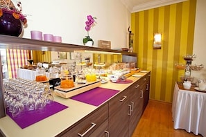 A breakfast buffet with various food items and a selection of wine glasses.