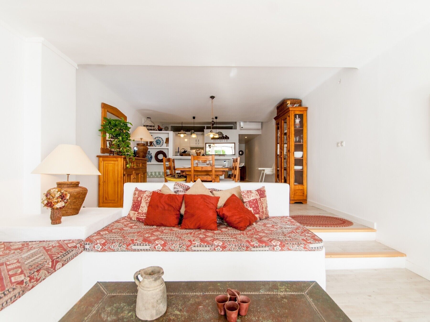 A living room with a sofa, a lamp, a vase, and a coffee table.
