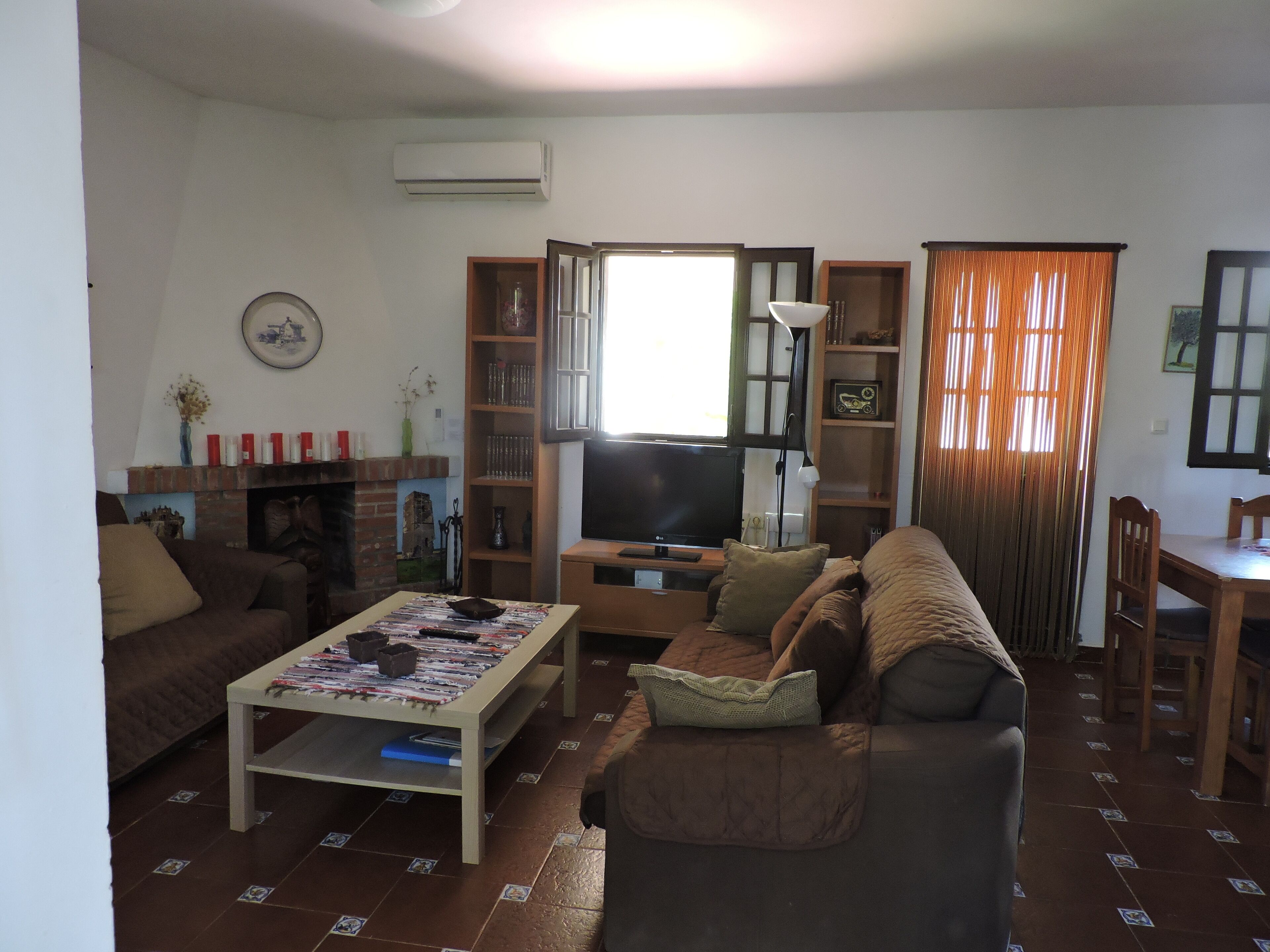 Una sala de estar con sofá, mesa de centro, televisor y estanterías.
