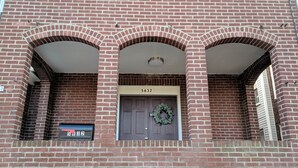 A brick building with a numbered door, a mailbox, and a wreath on the door. - Lovely, cozy Murray guest suite in Squirrel Hill  (Pittsburgh)