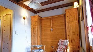 Una habitación acogedora con armarios de madera, un sillón mecedor y una mesita con revistas.