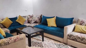A living room with a sofa set, a coffee table, and patterned cushions. - ^^ Superb apt near the beach  (Agadir)