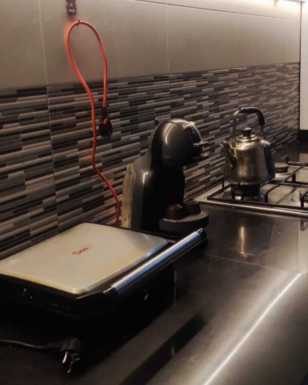 Eine moderne Küche mit integrierter Kaffeemaschine, Wasserkocher und einer tragbaren Waage auf der Arbeitsfläche.