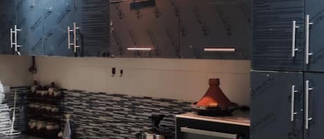 Una cocina moderna con armarios oscuros, una estufa a gas y un horno empotrado.