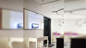 A modern interior with a white console table, a sofa with patterned cushions, and a wall clock. - ^^ Superb apt near the beach  (Agadir)