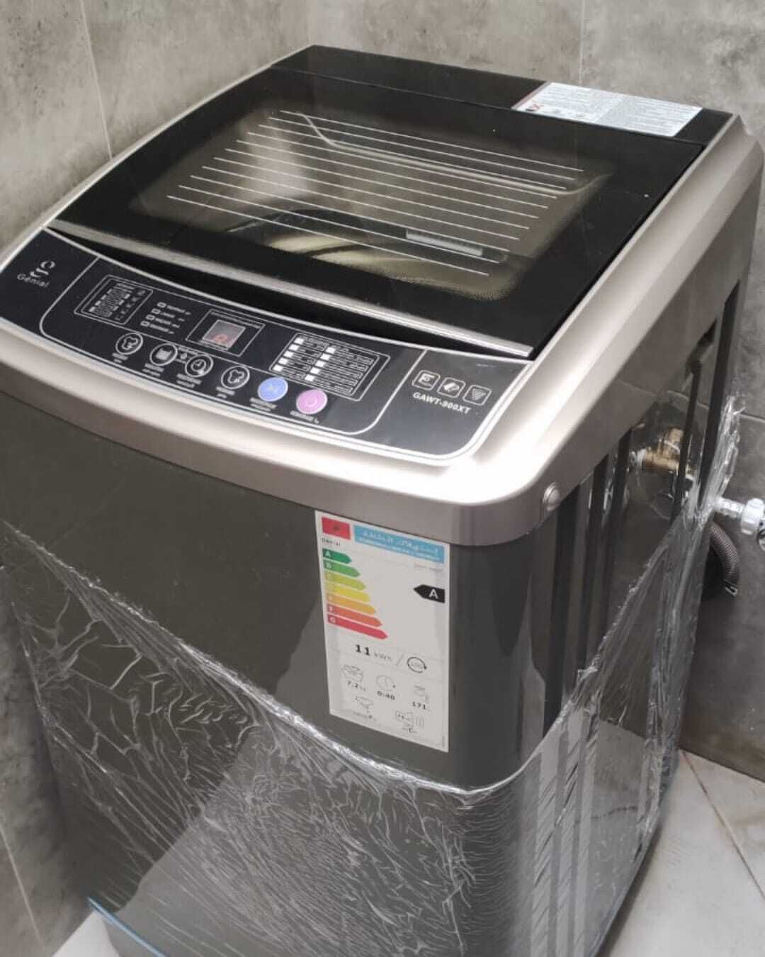 A compact, stainless steel, wall-mounted washing machine with a digital control panel and a water level indicator.