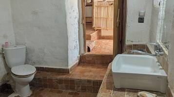 Ein Badezimmer mit Toilette, Waschbecken und Duschbereich.
