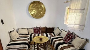 A cozy room with a sofa set, a round table, and a decorative plate on the wall.