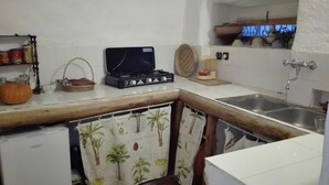A compact kitchen with a gas stove, a sink, and a refrigerator.
