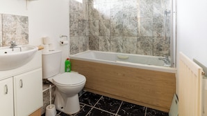 Uma casa de banho com lavatório, sanita e banheira.