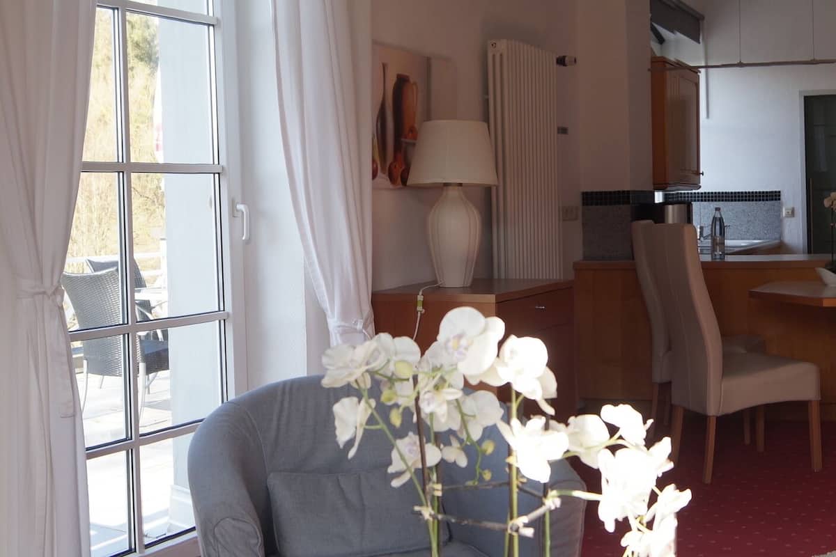 A hotel room with a bed, a desk, a chair, and a window.