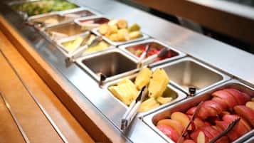 A buffet with various food items including fruits and vegetables.