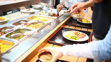 Un buffet proposant une variété de plats et d’ustensiles de service.