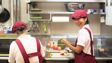 Una cocina con electrodomésticos de acero inoxidable, una tabla para cortar fruta y un bol en la encimera.