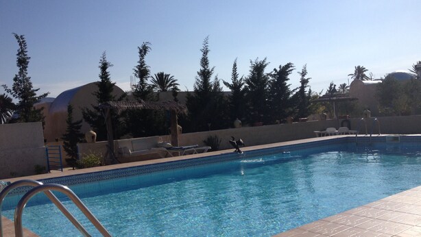 A swimming pool with tiled edges, a metal ladder, and lounge chairs. - House / Villa - Guizen djerba (djerba)