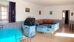 A room with a blue bed, a small table, a blue cabinet, and a window with curtains. - House / Villa - Guizen djerba (djerba)