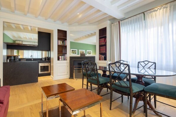 Una sala de estar con comedor, cocina y chimenea.