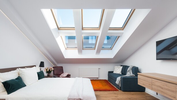 A modern bedroom with a skylight, a bed, a sofa, and a wooden floor. - Old Town, trendy Kazimierz, luxurious and spacious 2 bdrm, 2 bthrm, Apartment  (Kraków)