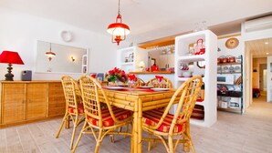 A dining area with a round table, four chairs, and a red hanging light fixture. - A. Oiza Sand Castle 24, Apt. 24 Edificio Canopus (Alcúdia)