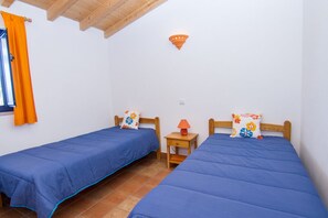 A bedroom with two single beds, a wooden ceiling, a small bedside table with a lamp, and a window with orange curtains. - Digne Orange Villa, Pool, BBQ (Rogil, Aljezur)