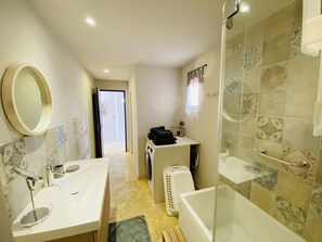 Ein modernes Badezimmer mit einem großen Spiegel, zwei Waschbecken, einer Dusche und einer Toilette.