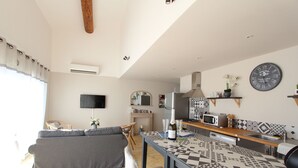 Eine moderne Küche mit Esstisch, einer Couch und einem Fernseher im Wohnbereich.