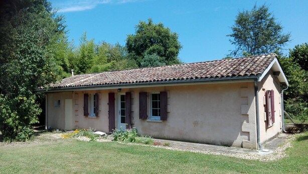 A small, single-story building with a tiled roof, a front door, and windows with shutters. - Small independent house in the countryside, near Saint Emilion, sleeps 4 (Lagorce)