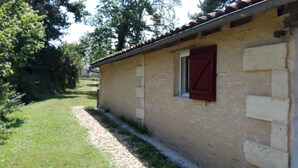 A small, single-story building with a tiled roof and a window with red shutters. - Small independent house in the countryside, near Saint Emilion, sleeps 4 (Lagorce)