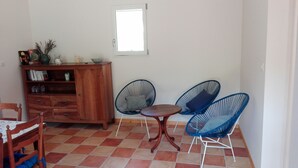 A dining area with a wooden cabinet, a small table, and two blue chairs. - Small independent house in the countryside, near Saint Emilion, sleeps 4 (Lagorce)