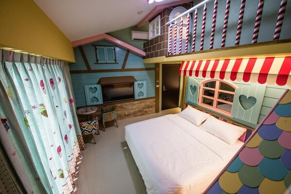 Una habitación con una cama litera, un pequeño escritorio con televisión y una ventana con forma de corazón.