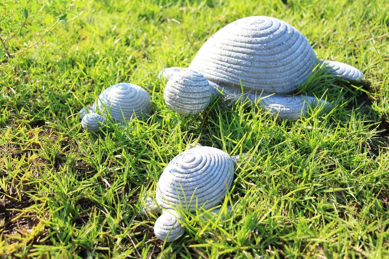 A grassy area with several large, textured objects resembling sculptures or decorative items.