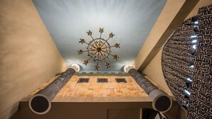 Una habitació amb sostre alt, un penjall decoratiu i un mur amb un disseny
