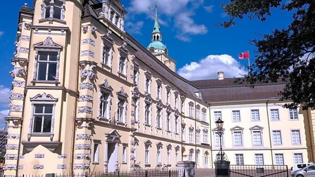 A historic building with classical architecture, a prominent dome, and a flag. - Wieting (Oldenburg)