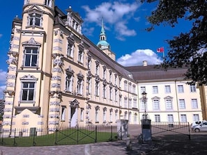 A historic building with classical architecture, a prominent dome, and a flag. - Wieting (Oldenburg)