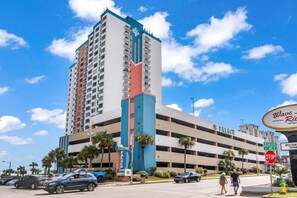 A multi-story hotel with a prominent 'The Palace' sign, a parking garage, and palm trees.