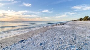 Une plage avec un ciel dégagé et une mer calme.