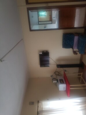 Enjoy a spacious room with a high ceiling, a large mirror, and a bathroom with a window.