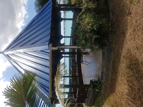Stunning architecture with a sloped roof and vertical beams, set amidst lush greenery and a paved walkway.