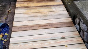 A wooden deck leading to a house entrance with a door and a small porch area. - Your comfortable vacation place! (Plattsburgh)
