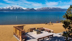 Una playa con una pasarela de madera, bancos y una pequeña construcción con techo.