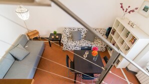 Una sala de estar moderna con un sofá, una mesa de comedor y una escalera.