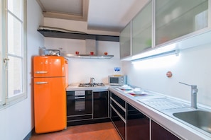 A compact kitchen with a gas stove, a microwave, a sink, and a refrigerator. - Comfortable and bright 80 sqm apartment, able to comfortably accommodate up to 5 people, is located on the third and top floor of a late 19th century building with lift. The property is located in an elegant neighborhood near the historic center of Flore (Firenze)