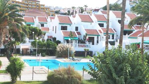 A resort with white buildings, red-tiled roofs, and a swimming pool. - Sunny Villa Holiday Home (Torviscas Bajo)
