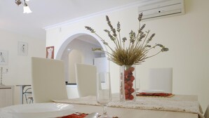 A dining table set with plates, cutlery, and a vase with dried plants. - Sunny Villa Holiday Home (Torviscas Bajo)