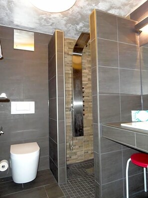 Une salle de bain moderne équipée d’une douche, de toilettes et d’un lavabo.