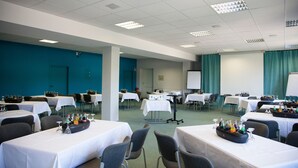 A conference room with tables set for a meeting, equipped with water bottles and glasses.