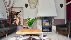 A modern living room with a stone fireplace, leather sofas, a cowhide rug, and a decorative bull head. - Wonderful secluded place - il wokini (Pigna)