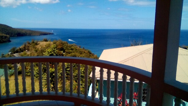 Ein Balkon mit Blick auf das Meer und eine entfernte Insel.