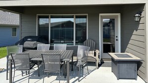 An outdoor patio with a table and chairs, a grill, and a small side table. - Bridges Bay Ranch style, single story home with 3 bedrooms and 2 bathrooms (Arnolds Park)