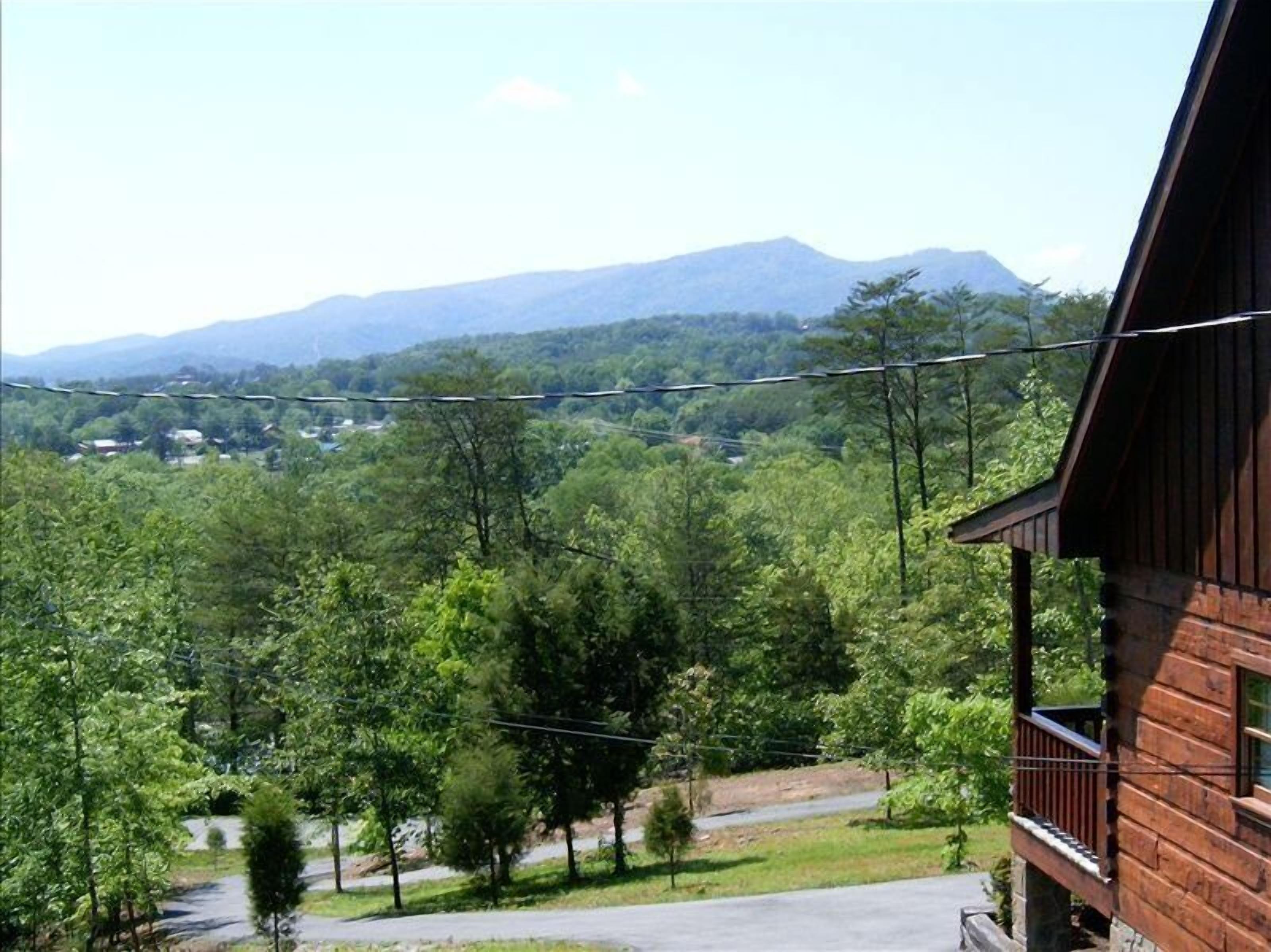 Une cabane en bois dotée d’un balcon donnant sur un paysage montagneux.